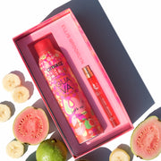 Amika x Ellis Brooklyn GUAVA GRANITA Perk Up Dry Shampoo and GUAVA GRANITA Eau de Parfum 10ml gift set next to whole and sliced guavas and slices of banana on white background