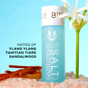 SALT 95ml Soothing Scented Body Oil in pink salt next to white flower and sandalwood with black text that reads "Notes of Ylang Ylang, Tahitian Tiare, Sandalwood" on blue background.