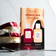 Dessert Duo box standing next to sliced red apple and vanilla ice cream stacked on one another, behind spoon, on marble background. 