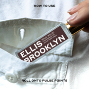 Model wearing white button-down shirt placing Milk Wood Fragrance Oil 15ml into shirt pocket between black text that reads "How To Use Roll Onto Pulse Points".
