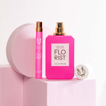 Florist 10ml Eau De Parfum Travel Spay next to Florist 50ml Eau De Parfum with cap removed on light pink block, next to light pink circle prop and light pink square prop, on light pink background.