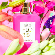 Florist 50ml Eau De Parfum on pink background surrounded by pink, green, yellow, orange, and purple flowers.