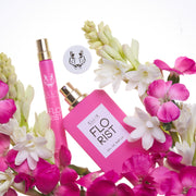 Florist 50ml Eau De Parfum with cap removed and Florist 10ml Eau De Parfum Travel Spray on white background surrounded by pink and white flowers.