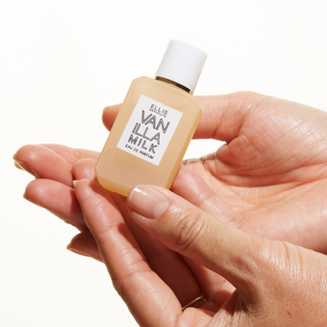 Model wearing gold ring holding Vanilla Milk 7.5ml Eau De Parfum Mini Dabber in both hands. 