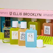Pink and green Chapters Mini Fragrance Gift Set box showing Myth 7.5ml Eau De Parfum Mini Dabber, Salt 7.5ml Eau De Parfum Mini Dabber, Sun Fruit 7.5ml Eau De Parfum Mini Dabber, and Vanilla MIlk 7.5ml Eau De Parfum Mini Dabber, on white table behind Myth 7.5ml Eau De Parfum Mini Dabber,  Sun Fruit 7.5ml Eau De Parfum Mini Dabber, Vanilla Milk 7.5ml Eau De Parfum Mini Dabber, and Salt 7.5ml Eau De parfum Mini Dabber with cap removed, on white background.